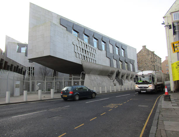 Edinburgh, UK - December 29, 2019: Scottish Parliament Building on The Royal Mile, Edinburgh, United Kingdom. Tourists walk back into the city centre after visiting the Scottish Parliament Building in Edinburgh.