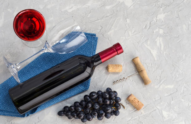 istock Bottle of wine, wine glass, grapes and corkscrew on gray table. 1204686344
