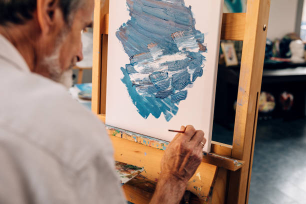 istock Senior artist making autograph on his abstract painting 1204687417