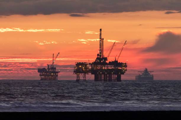 plate-forme de forage de pétrole offshore en californie méridionale pendant le coucher du soleil - oil crane oil rig derrick crane photos et images de collection