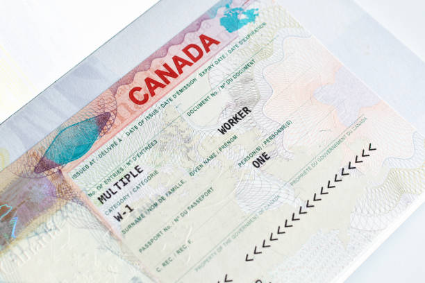 Canadian working visa in passport. Immigration to Canada concept. Canadian working visa in passport closeup. Immigration to Canada concept. embassy photos stock pictures, royalty-free photos & images