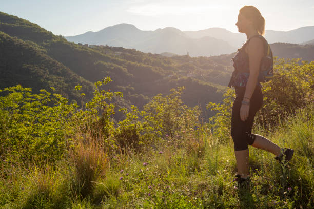 istock Female hiker traverses grassy ridge at sunrise 1204699809