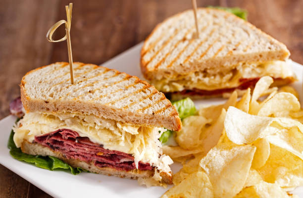 Classic Reuben Sandwich with Chips Reuben Sandwich Cut in Half and Served with Potato Chips at a Local Cafe reuben sandwich stock pictures, royalty-free photos & images