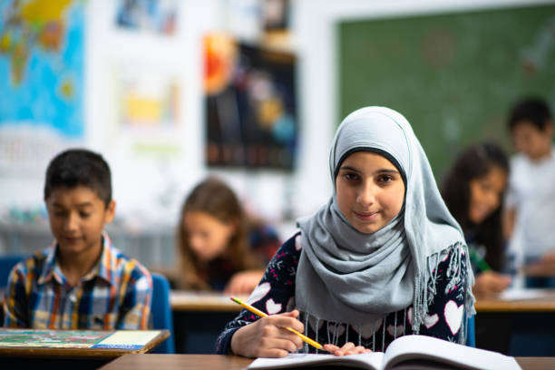 istock Afghan Elementary School Girl Writing in Class stock photo 1204702618