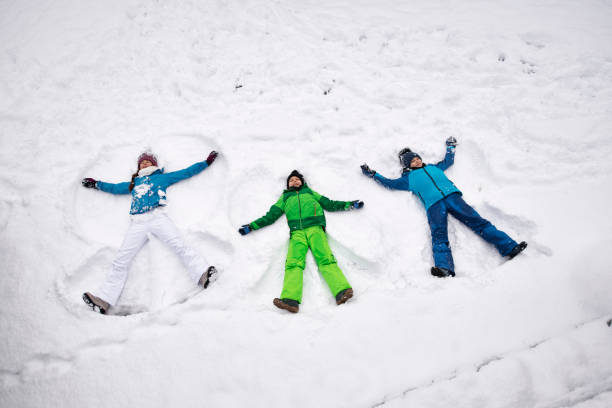istock Kids enjoying making snow angels in fresh snow 1204703344