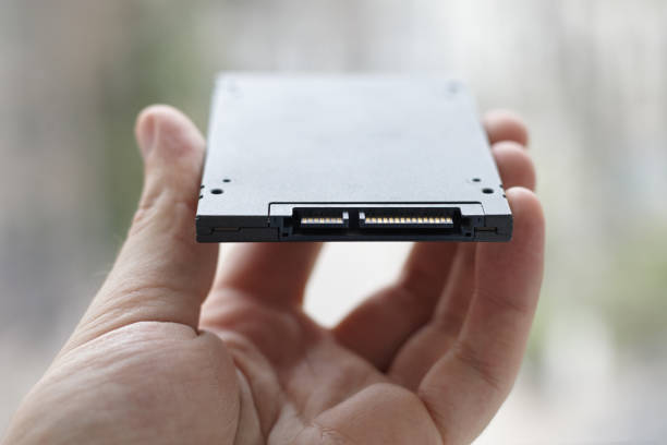 sata plug at solid state disk drive close up. person holds information store device. stock photo