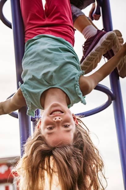 dziewczyna do góry nogami na placu zabaw - child jungle gym playground laughing zdjęcia i obrazy z banku zdjęć