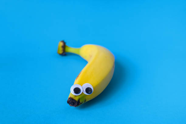 istock Anthropomorphic Face with Googly Eyes on a Banana with a Colored Background 1204707870
