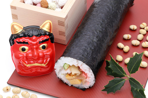 Japanese traditional Setsubun event, Ehomaki sushi roll and Masks of Oni demon on a dish