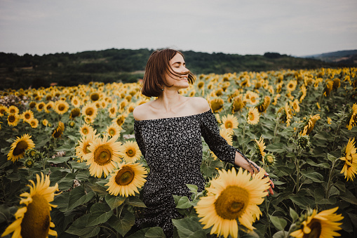 Beautiful girl in field of sunflowers