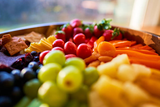 Vegan food including fruit, vegetables, vegan cheese, and chips in all the colors of the rainbow.
