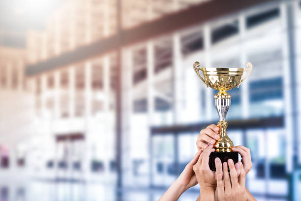 istock Business people holding gold trophy award 1204730500