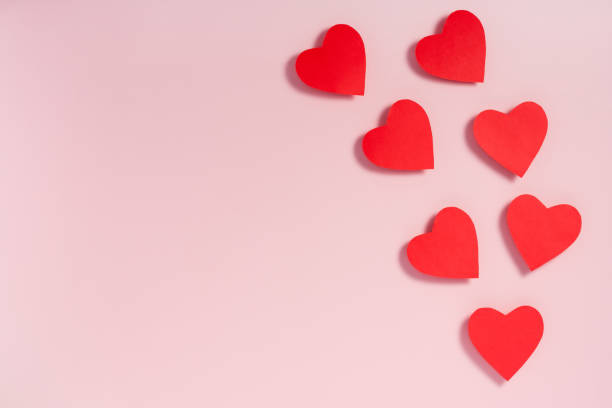 istock Valentine's day. Red paper hearts with shadow on pink surface. 1204732626
