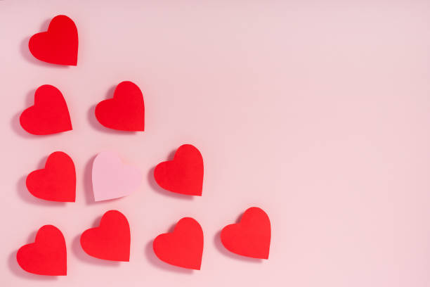 istock Valentine's day. Red paper hearts with shadow on pink surface. 1204732688