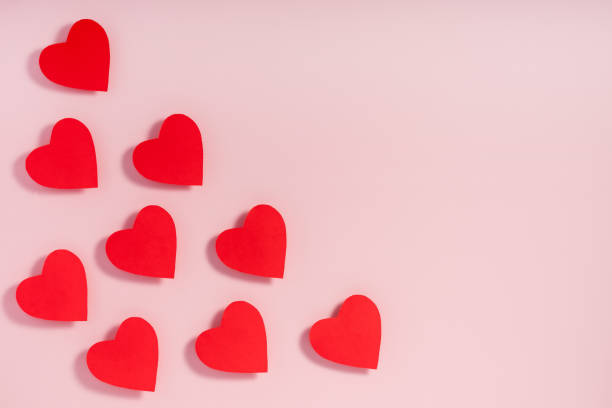 istock Valentine's day. Red paper hearts with shadow on pink surface. 1204732758