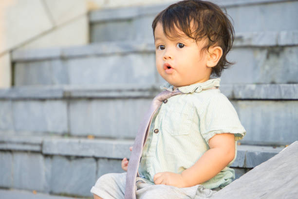 Cute baby boy stands and licking window
