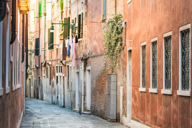 alley with old traditional houses at venice, italy. - walking point of view imagens e fotografias de stock