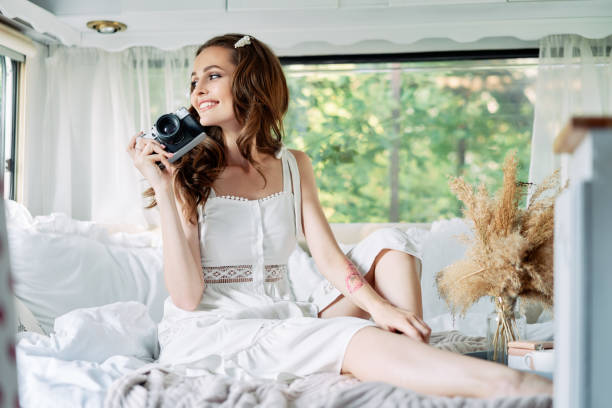 istock Young beautiful woman with camera relax inside the camper van 1204747488