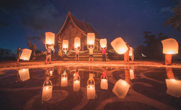 grupo de jovens lançando lanternas no templo sirindhorn wararam phu prao - buddhist festival - fotografias e filmes do acervo