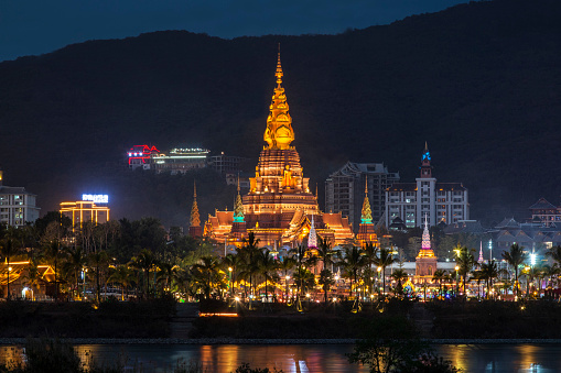 Jinghong, China - January 2, 2020: Big Golden Pagoda also called Dajin Pagoda reflecting on the Mekong River
