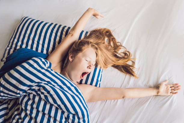 istock Beautiful young woman lying down in bed and sleeping. Do not get enough sleep concept 1204755490