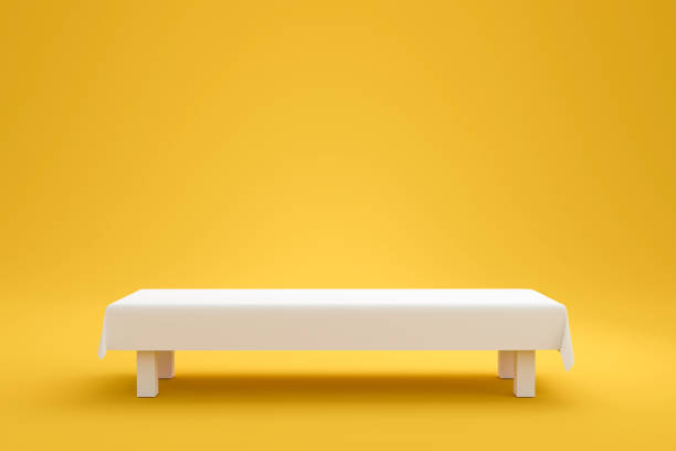 istock White top table and fabric cloth or empty pedestal display on vivid yellow summer background with minimal style. Blank stand for showing product. 3D rendering. 1204757294
