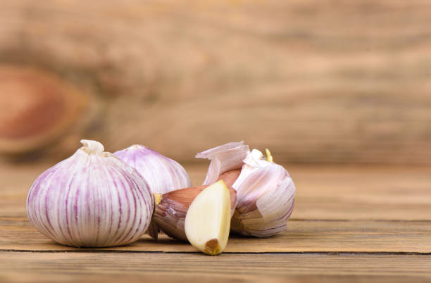 istock Several heads of garlic on a wooden background. 1204757577