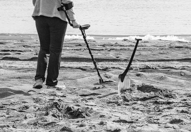 istock Finding coins in the sand on the beach with a metal detector 1204757645