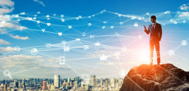 istock Communication network concept. Young businessman on the mountain top. 1204762220
