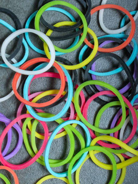 istock Multiple colored rubberbands in a pile on a gray textured background 1204763286