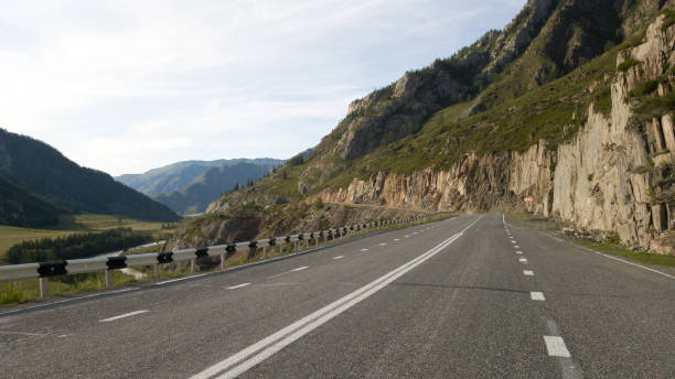 istock Beautiful flat empty asphalt road among the mountains. Accurate road markings. Traffic management in hard-to-reach places. Travel to Russia 1204768959
