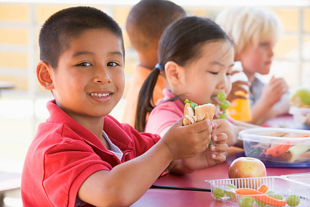 jardim de infância crianças a comer o almoço - child eating imagens e fotografias de stock