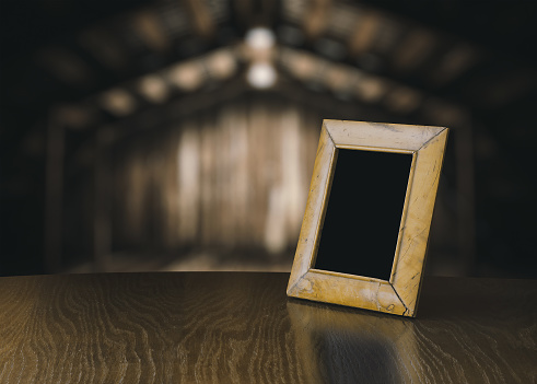retro photo frame on vintage desk in old wooden interior with light bulb