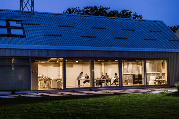 istock Business team sitting inside of office while working late on wireless technology. 1204772780