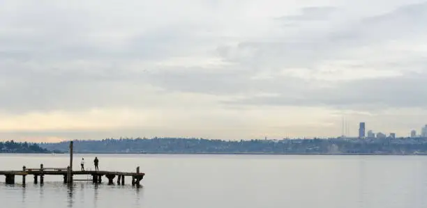 Beachgoers at Kirkland  Marina pier looking at Seattle skyline across lake Washington