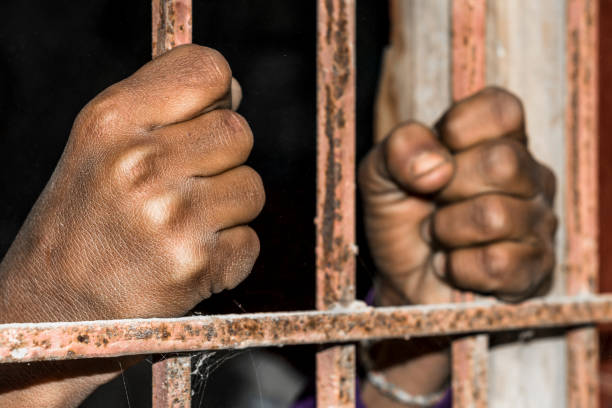 closeup of brown hands of prison inside the jail closeup of brown hands of prison inside the jail child arrest stock pictures, royalty-free photos & images