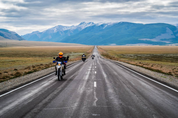 Altai, Russia - September, 14, 2019: Motorcycle column traveling along the Chuysky tract at dawn, landscape with a highway
