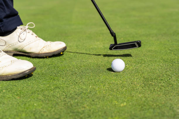 istock Golf ball and a person's shoes on a golf course 1204778642