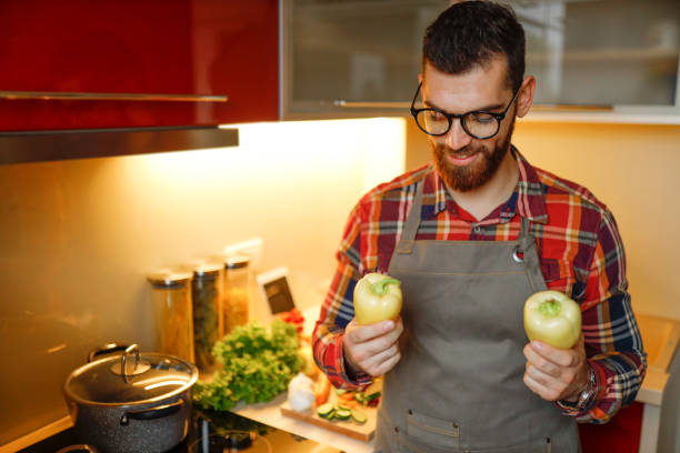 istock Man holding two yellow bell peppers 1204779362