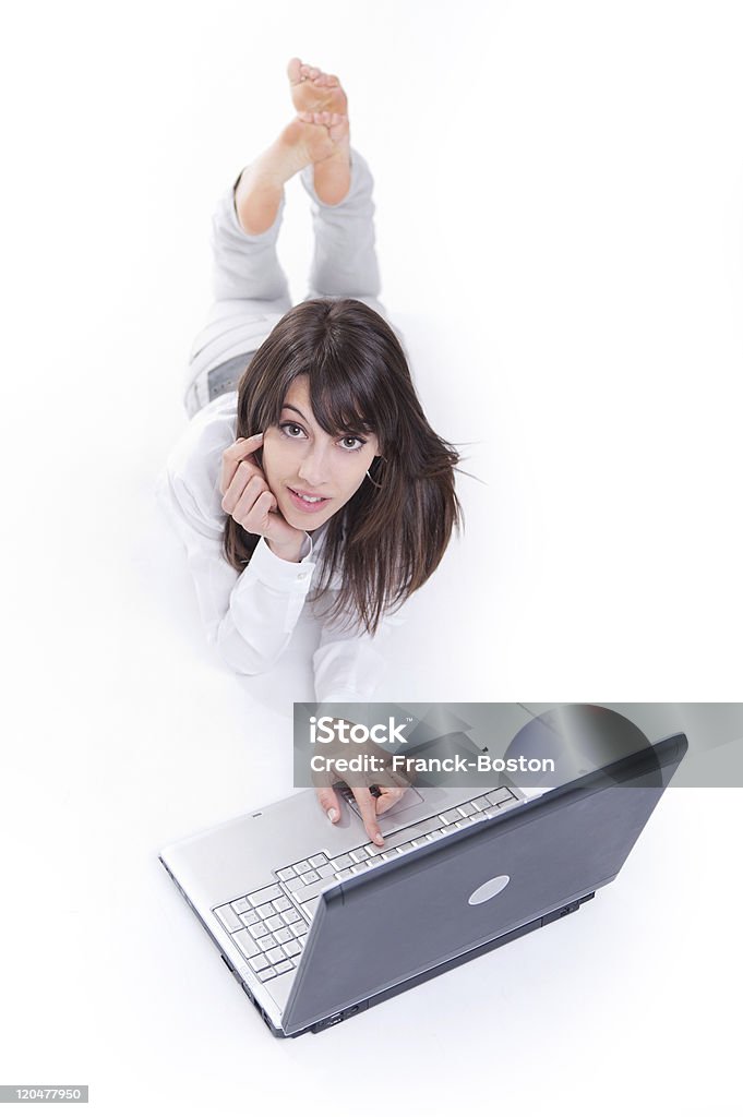 Giovane donna utilizza un computer portatile - Foto stock royalty-free di Cercare