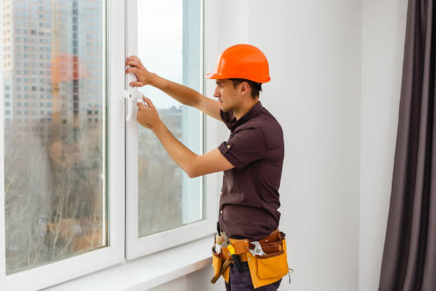 istock Carpenter repairing window frames, home is being updated to be sold 1204780110