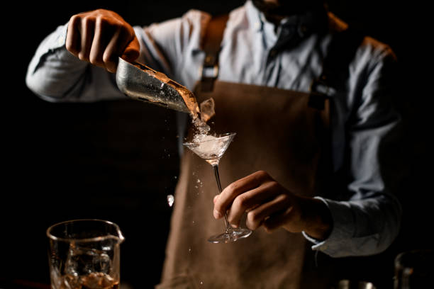 istock Bartender putting a crushed ice to the little martini glass with special spoon 1204783184
