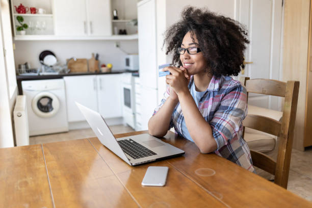 istock Woman using credit card at home 1204785833