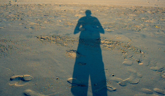 Person shadows with reflection on the ground