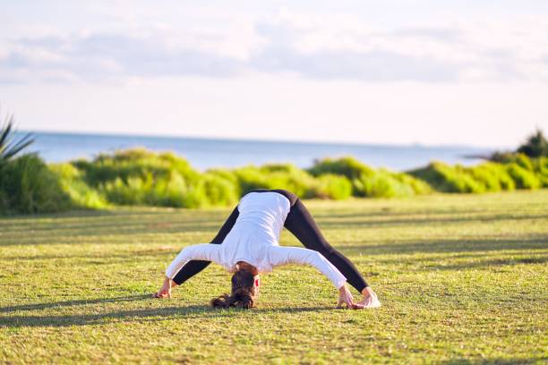 istock Young beautiful sportwoman practicing yoga. Coach teaching postures at park 1204796564
