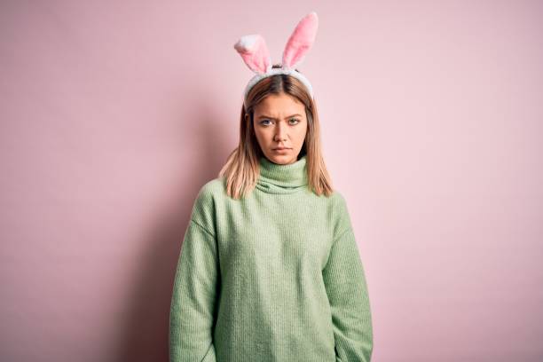 istock Young beautiful woman wearing easter rabbit ears standing over isolated pink background skeptic and nervous, frowning upset because of problem. Negative person. 1204797240