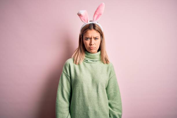 istock Young beautiful woman wearing easter rabbit ears standing over isolated pink background depressed and worry for distress, crying angry and afraid. Sad expression. 1204797515