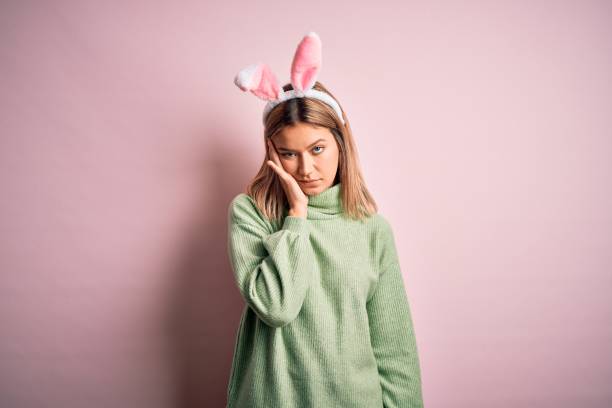 istock Young beautiful woman wearing easter rabbit ears standing over isolated pink background thinking looking tired and bored with depression problems with crossed arms. 1204797734