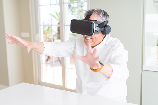 Man wearing virtual reality glasses smiling looking very happy and excited