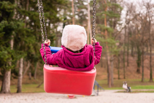 istock Little girl swinging on a swing. 1204805651